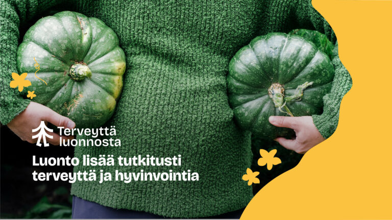 Henikö jolla on vihreä villapaita pitelee molemissa käsissään yhtä kurpitsaa jotka ovat melko saman väriset paidan kanssa. Kuvassa lukee teksti "luonto lisää tutkitusti terveyttä ja hyvinvointia".